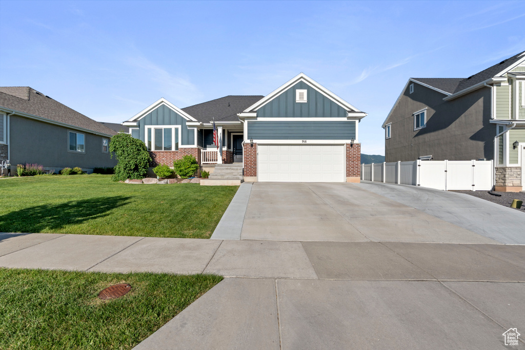 Craftsman-style house with board and batten siding, brick siding, concrete driveway, and a garage