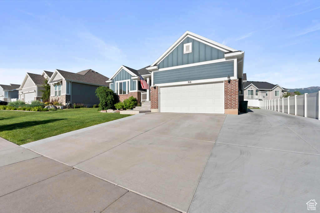 Craftsman inspired home featuring board and batten siding, driveway, brick siding, and a residential view