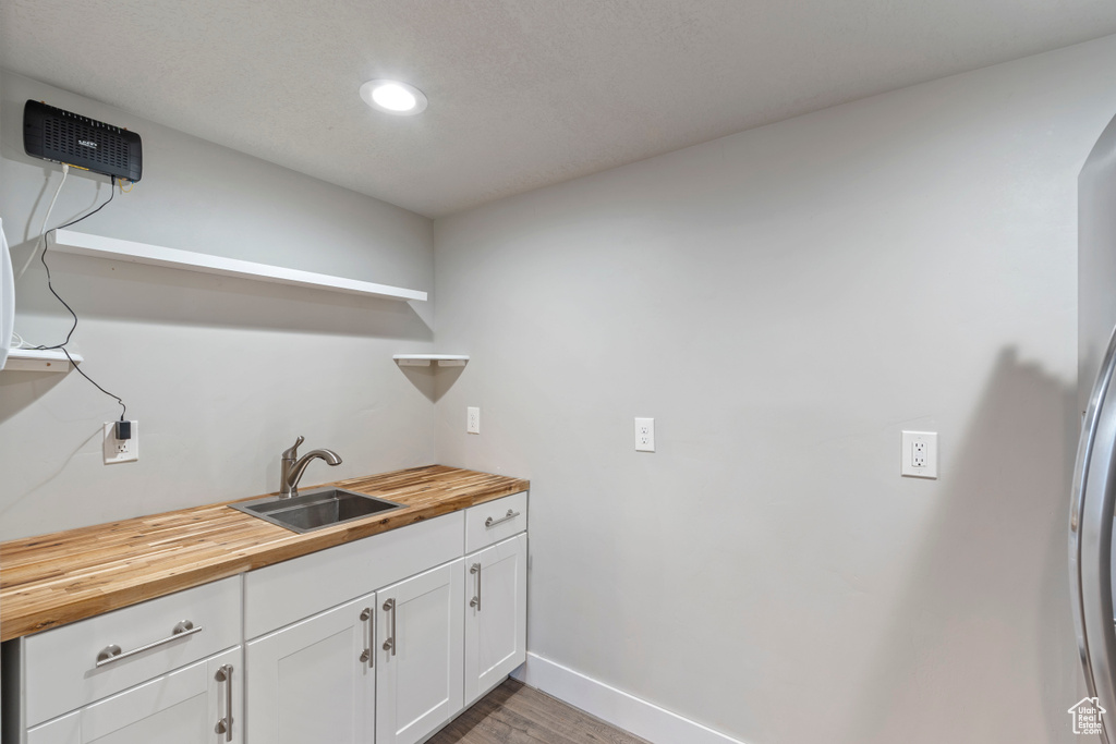 Laundry area with recessed lighting and light wood-style flooring