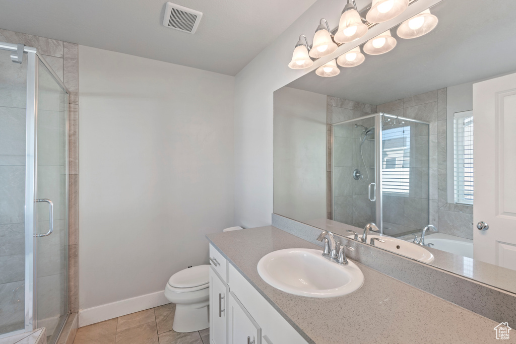 Full bath featuring vanity, a stall shower, and tile patterned floors