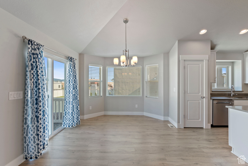 Unfurnished dining area featuring a chandelier, light wood-type flooring, and recessed lighting