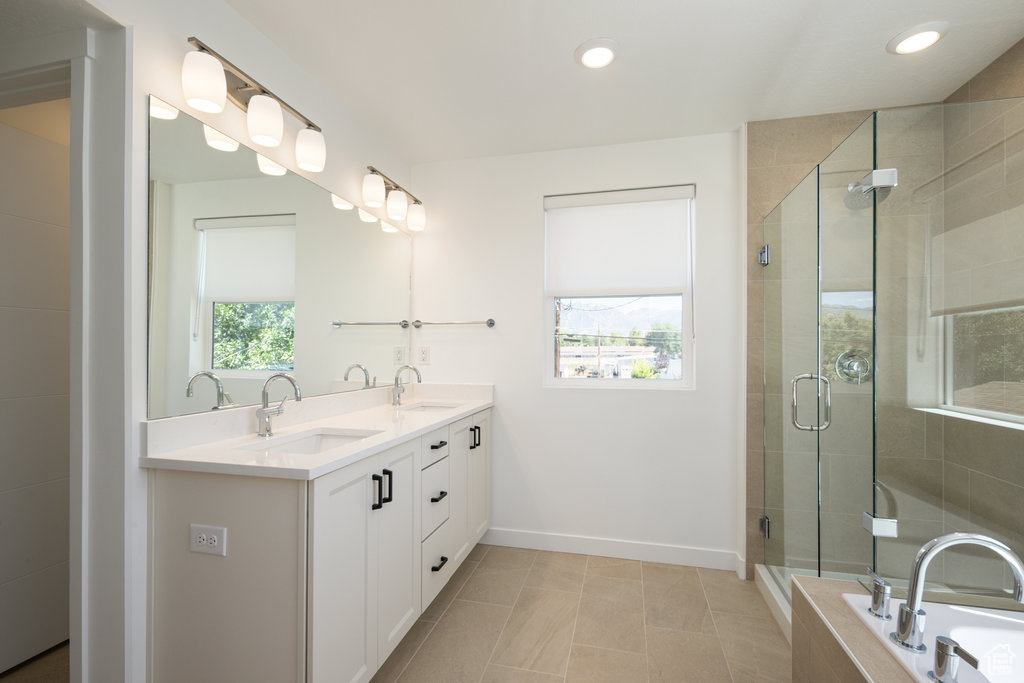 Full bathroom featuring double vanity, a bath, a stall shower, recessed lighting, and tile patterned flooring