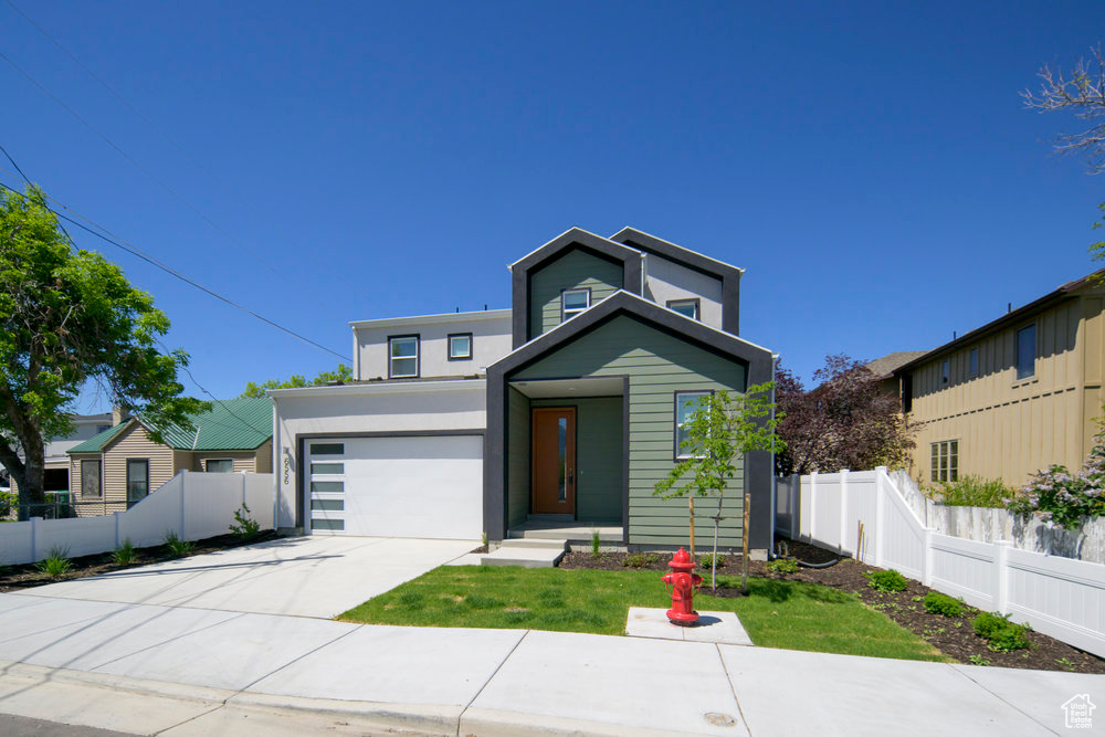 Contemporary home featuring driveway, a garage, and stucco siding