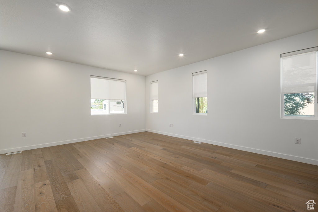 Spare room featuring plenty of natural light, wood finished floors, and recessed lighting