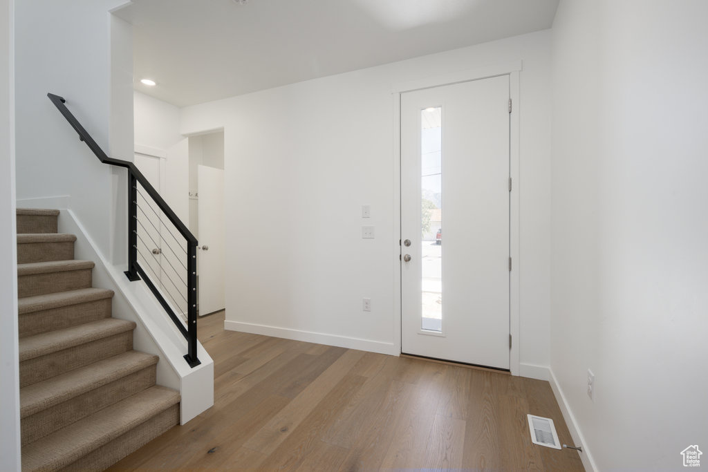 Foyer entrance featuring light wood-type flooring, stairway, and recessed lighting