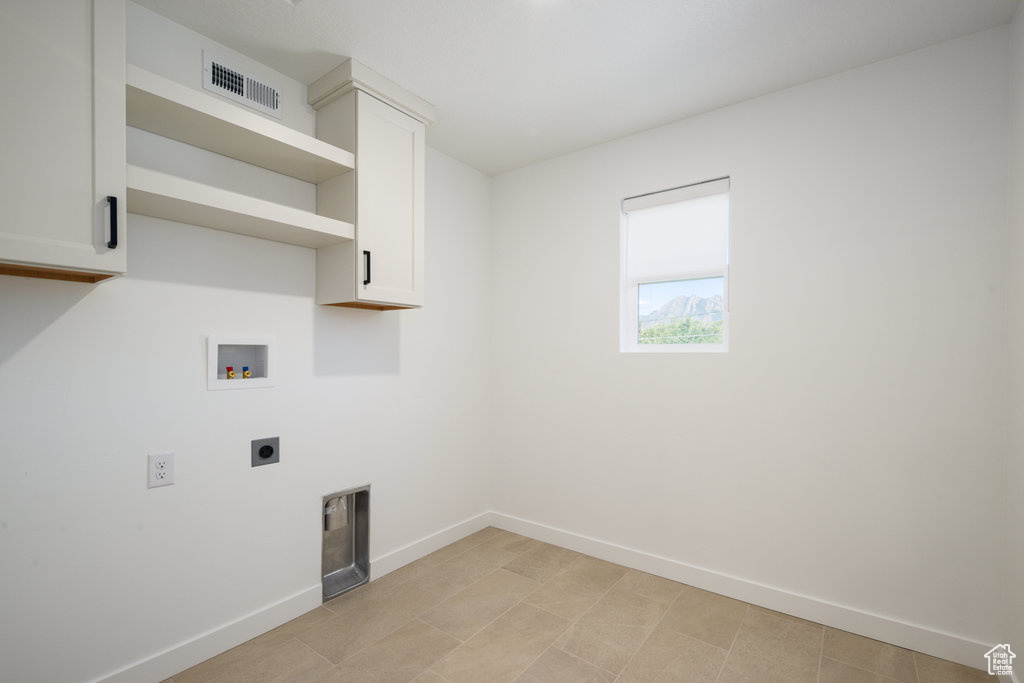 Laundry room with hookup for an electric dryer, hookup for a washing machine, and cabinet space