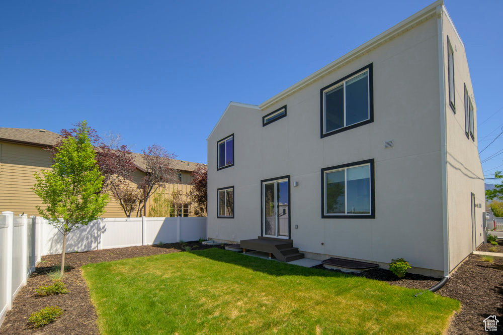 Rear view of property featuring a fenced backyard and stucco siding