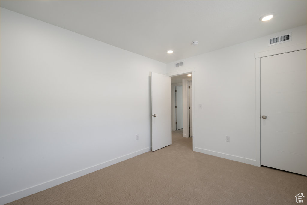 Unfurnished bedroom with recessed lighting and light colored carpet
