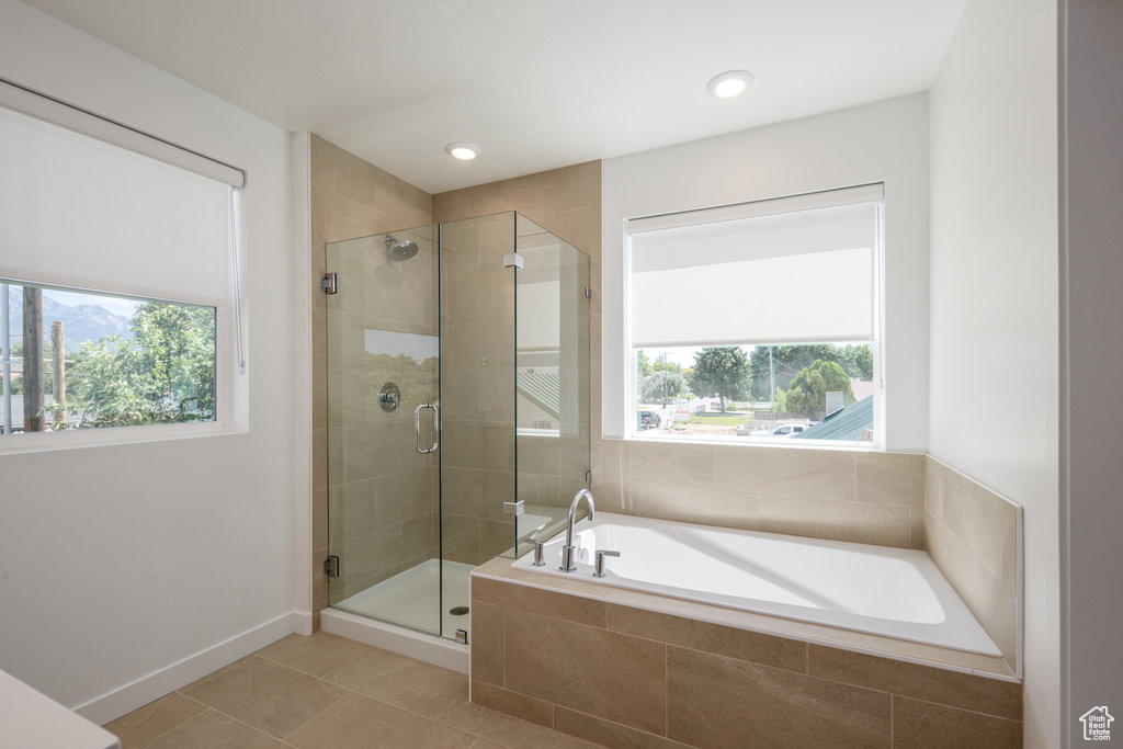 Bathroom with tile patterned floors, plenty of natural light, a garden tub, and a shower stall