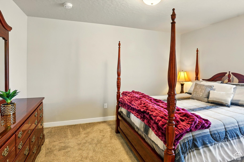 Bedroom with light carpet and baseboards