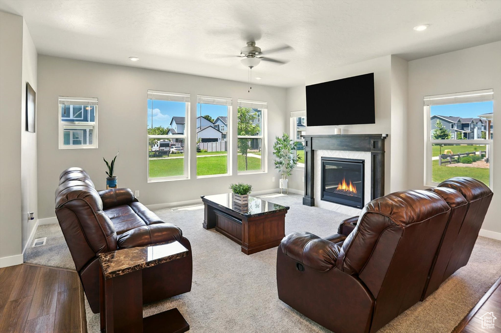 Living area with a ceiling fan, wood finished floors, a high end fireplace, plenty of natural light, and recessed lighting
