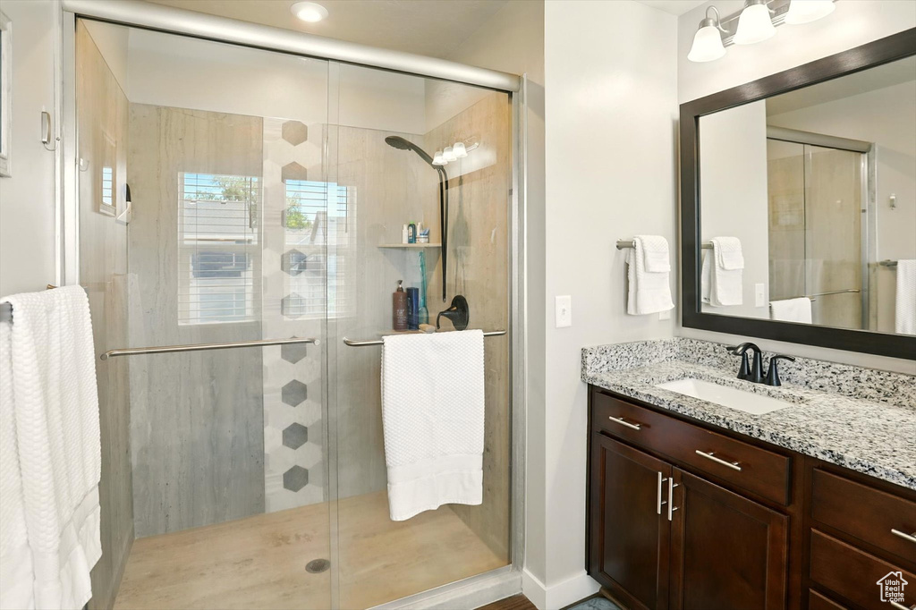 Full bathroom with vanity and a shower stall
