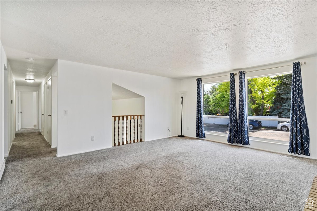 Spare room with a textured ceiling and carpet flooring