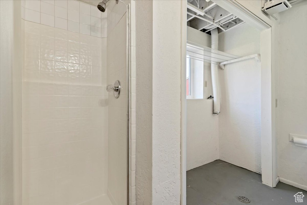 Full bath featuring a shower stall and finished concrete flooring
