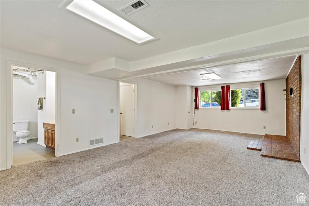 Below grade area with light colored carpet and baseboards