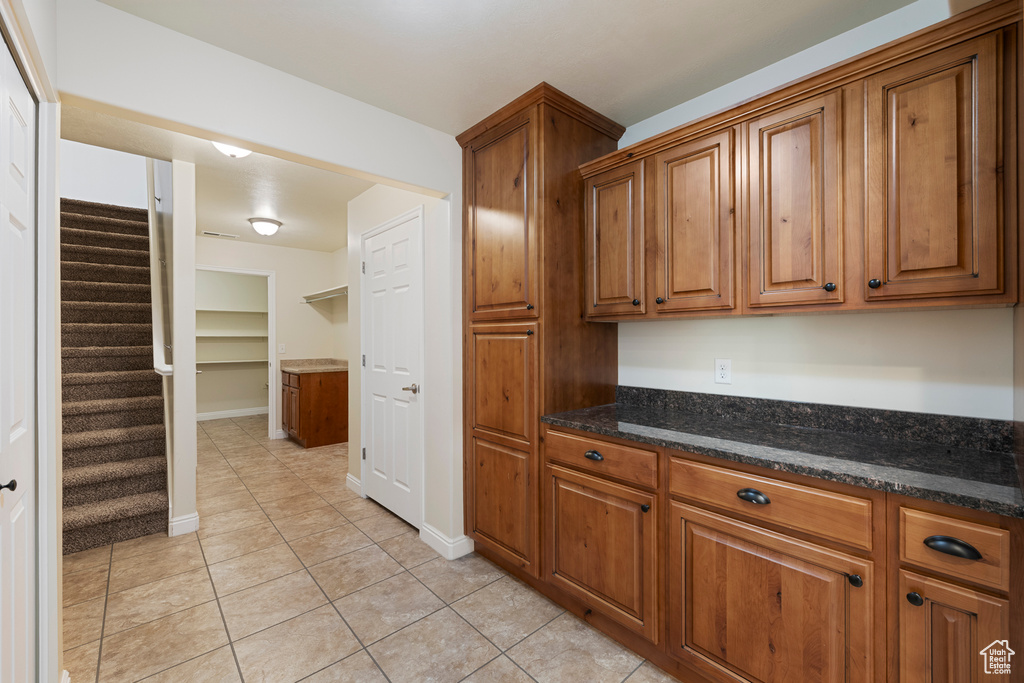 Kitchen with brown cabinets and light tile patterned flooring