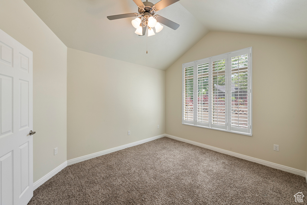 Spare room with carpet floors, lofted ceiling, and a ceiling fan