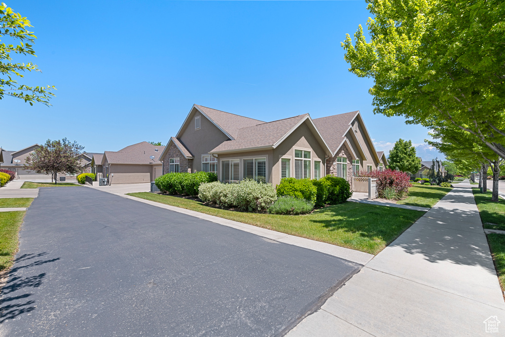 View of front of home with stucco siding, a front yard, and a residential view