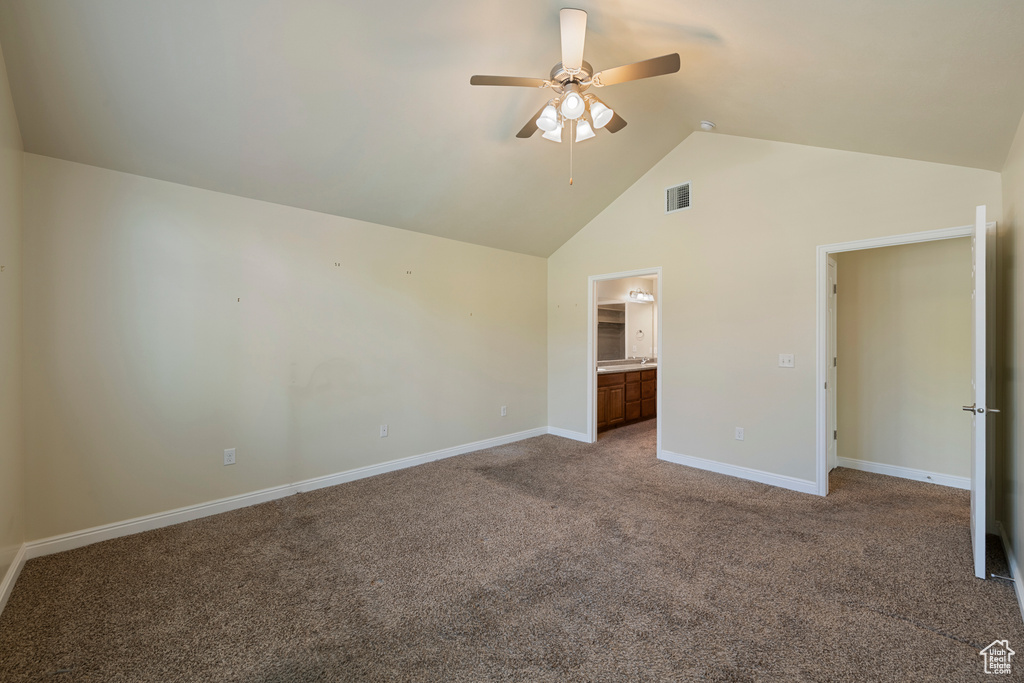 Unfurnished bedroom featuring carpet flooring, high vaulted ceiling, connected bathroom, and ceiling fan