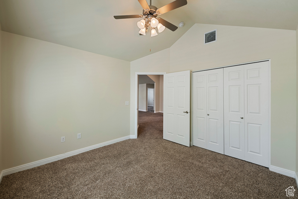 Unfurnished bedroom featuring carpet floors, high vaulted ceiling, ceiling fan, and a closet