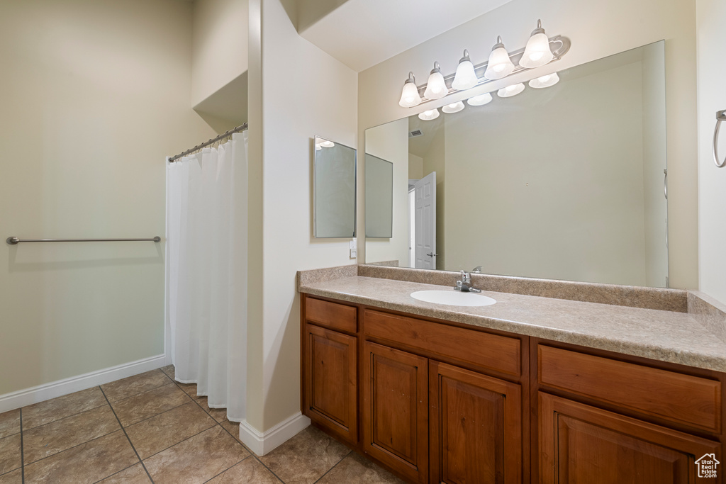 Full bath with vanity, tile patterned flooring, and a shower with shower curtain