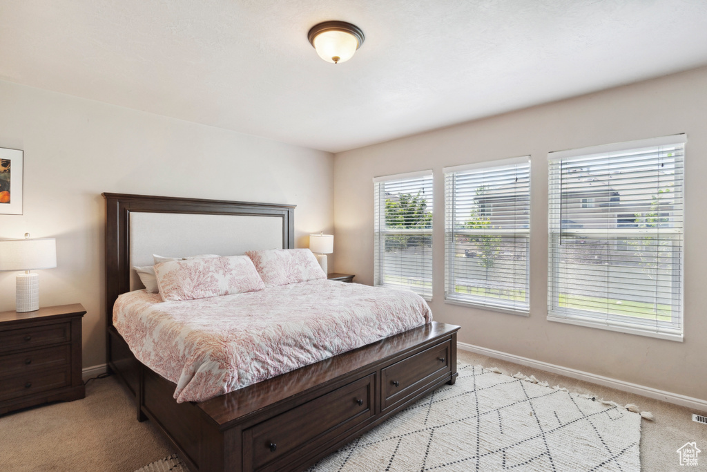 Bedroom featuring light carpet and baseboards
