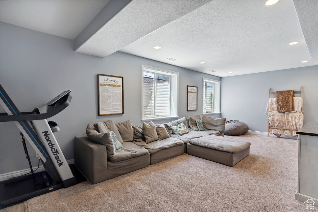 Carpeted living room featuring recessed lighting and a textured ceiling