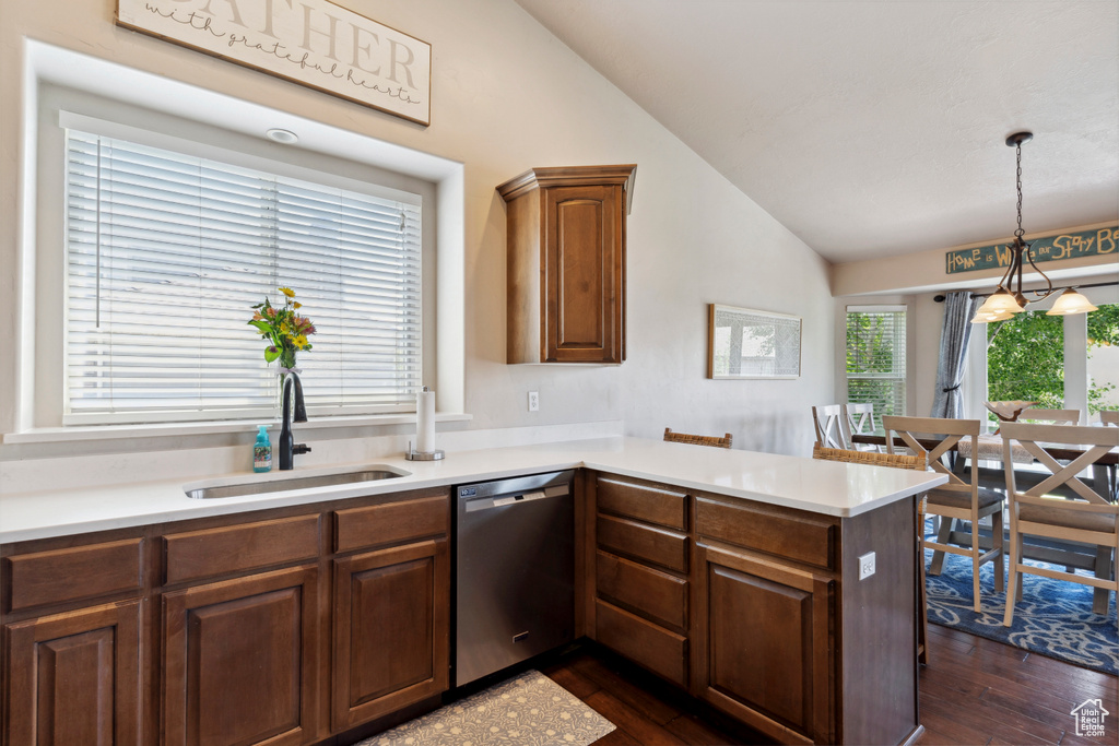Kitchen featuring dishwasher, lofted ceiling, dark wood finished floors, a peninsula, and light countertops