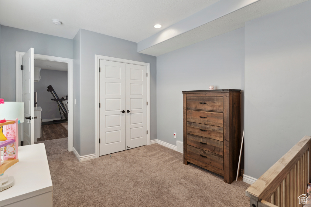 Bedroom featuring light colored carpet and a closet