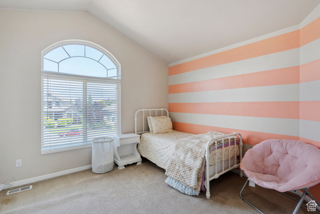 Bedroom with vaulted ceiling and carpet flooring