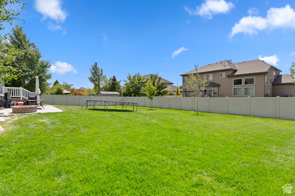 Fenced backyard featuring a patio and a trampoline