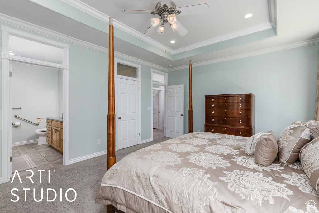 Bedroom featuring light carpet, ornamental molding, ensuite bath, recessed lighting, and a tray ceiling