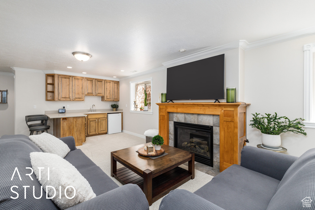 Living room with ornamental molding, light carpet, a tiled fireplace, and recessed lighting