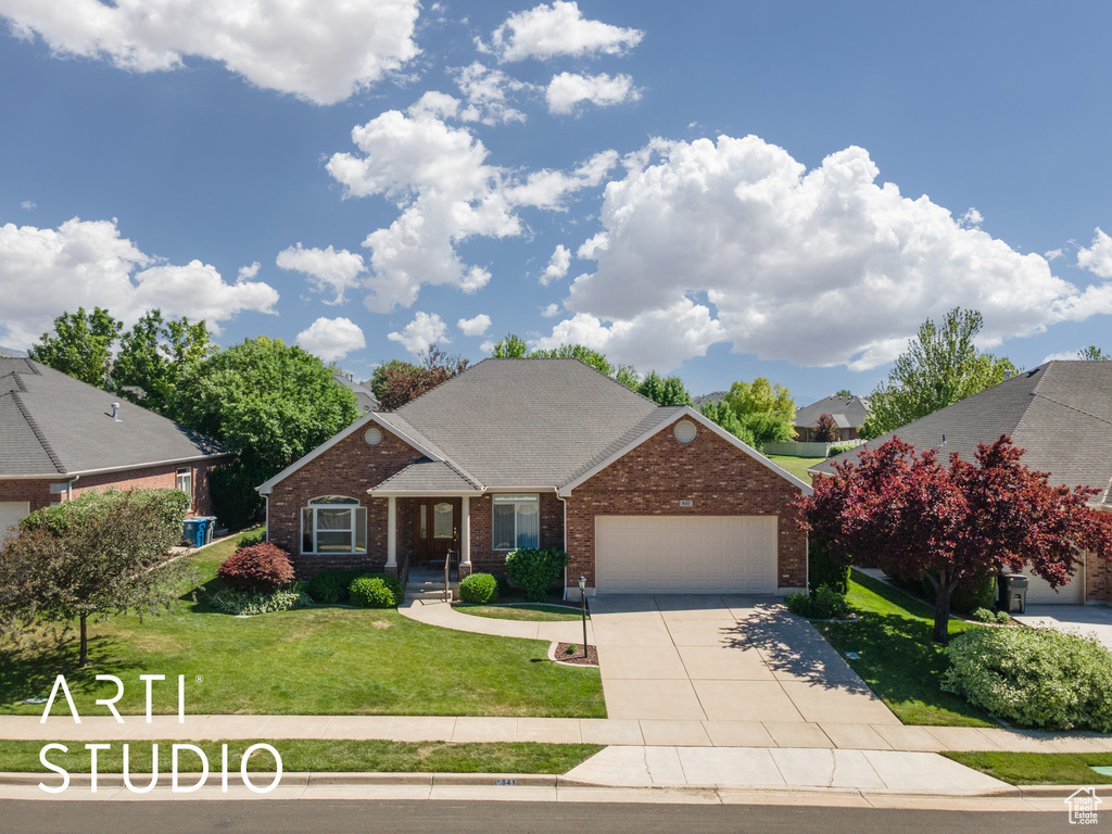 View of front of home with brick siding, a garage, driveway, a front lawn, and a shingled roof