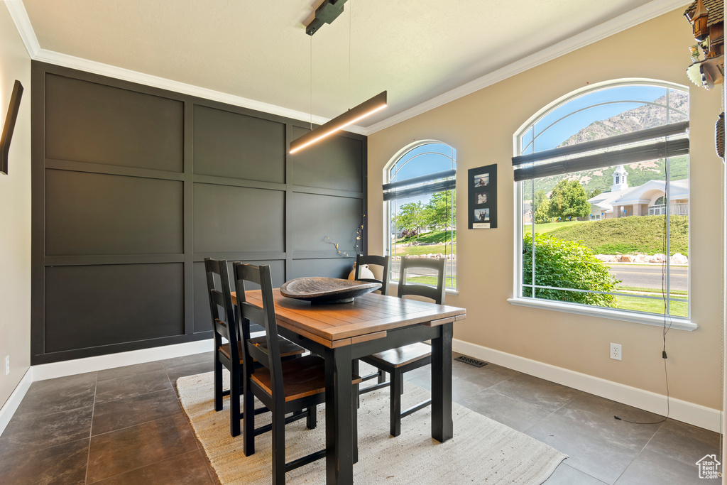 Dining room featuring crown molding and a decorative wall
