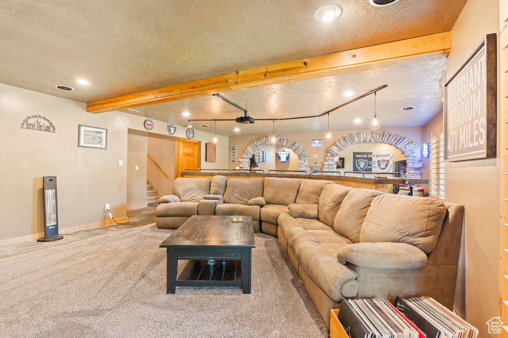 Carpeted living room featuring a textured ceiling, stairs, beamed ceiling, and recessed lighting