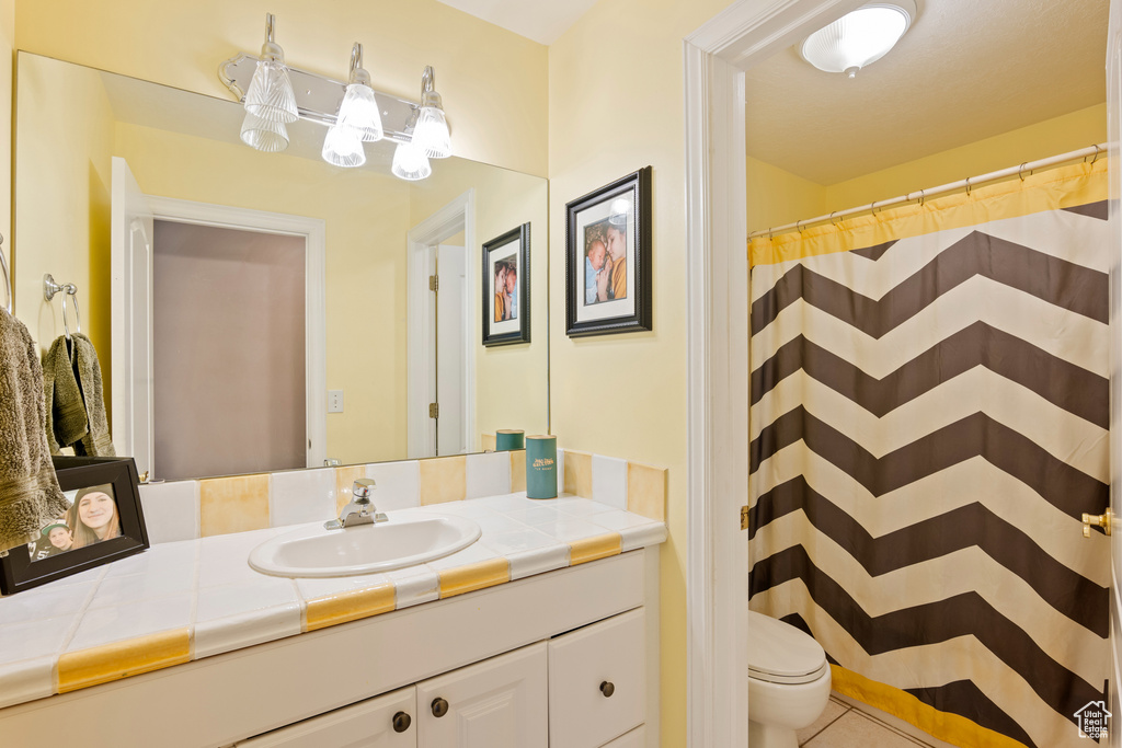 Bathroom with vanity, tile patterned floors, and a shower with curtain