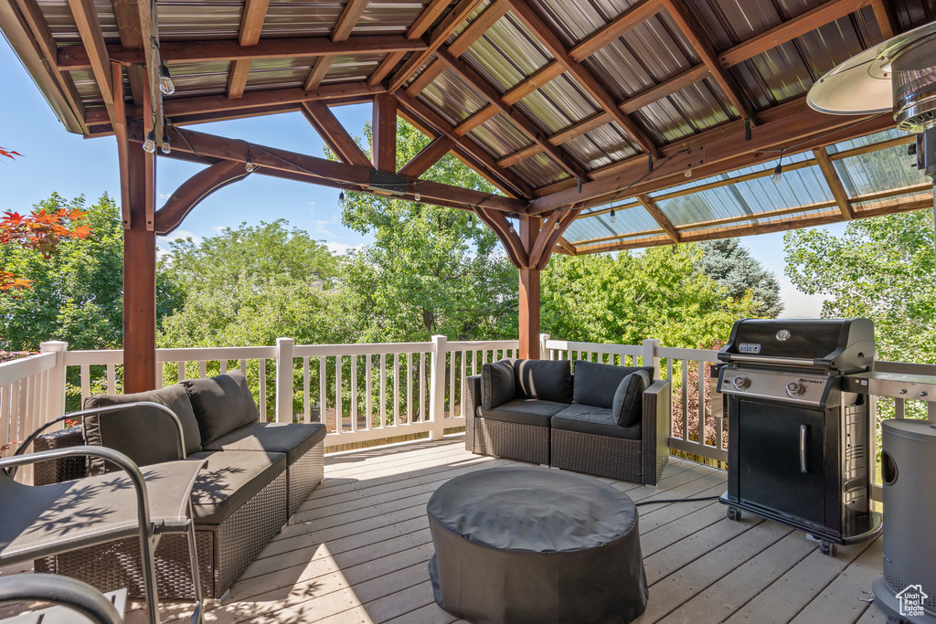 Wooden deck featuring grilling area and an outdoor living space
