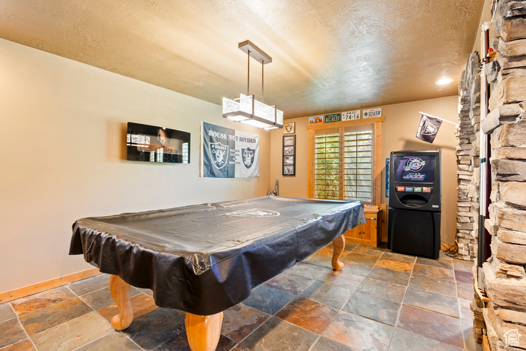 Game room with stone tile floors, a textured ceiling, billiards table, and recessed lighting
