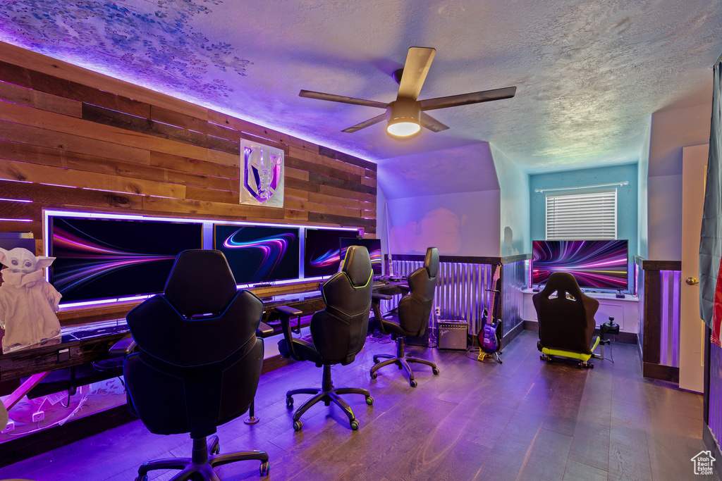 Office with a ceiling fan, wood finished floors, a textured ceiling, and wooden walls