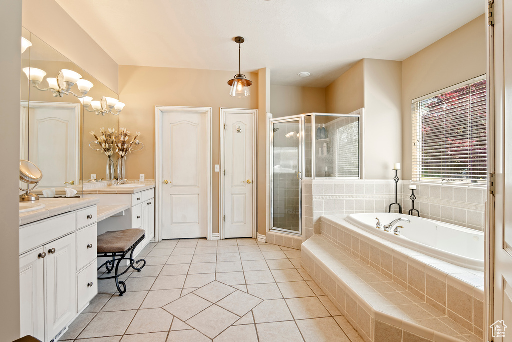 Full bath with vanity, a bath, a shower stall, tile patterned flooring, and a chandelier