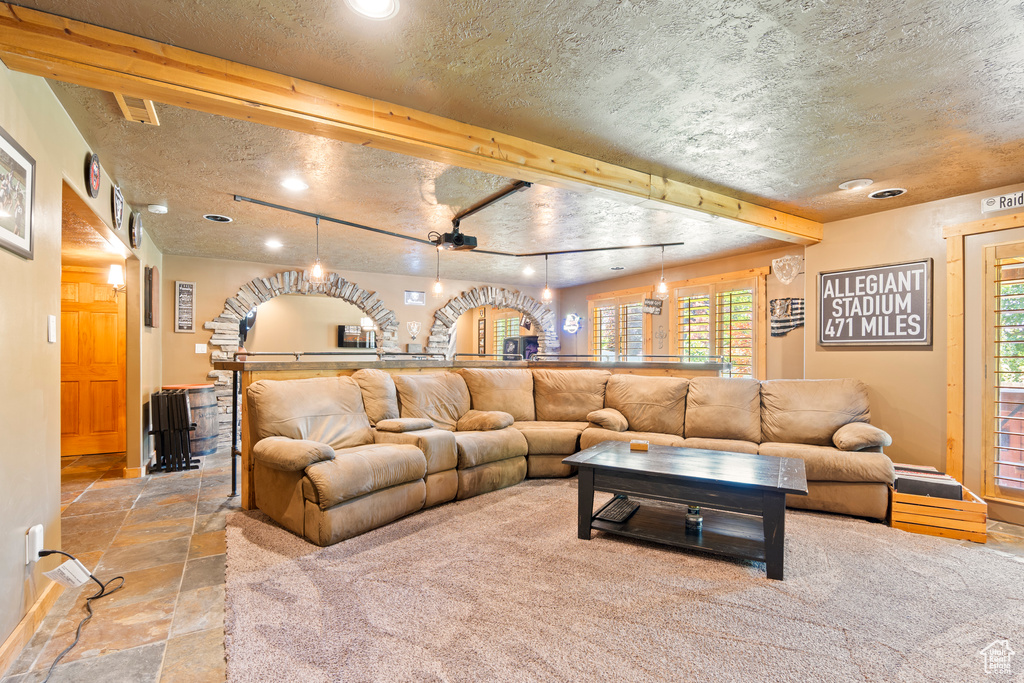 Living room featuring stone tile floors, recessed lighting, and a textured ceiling