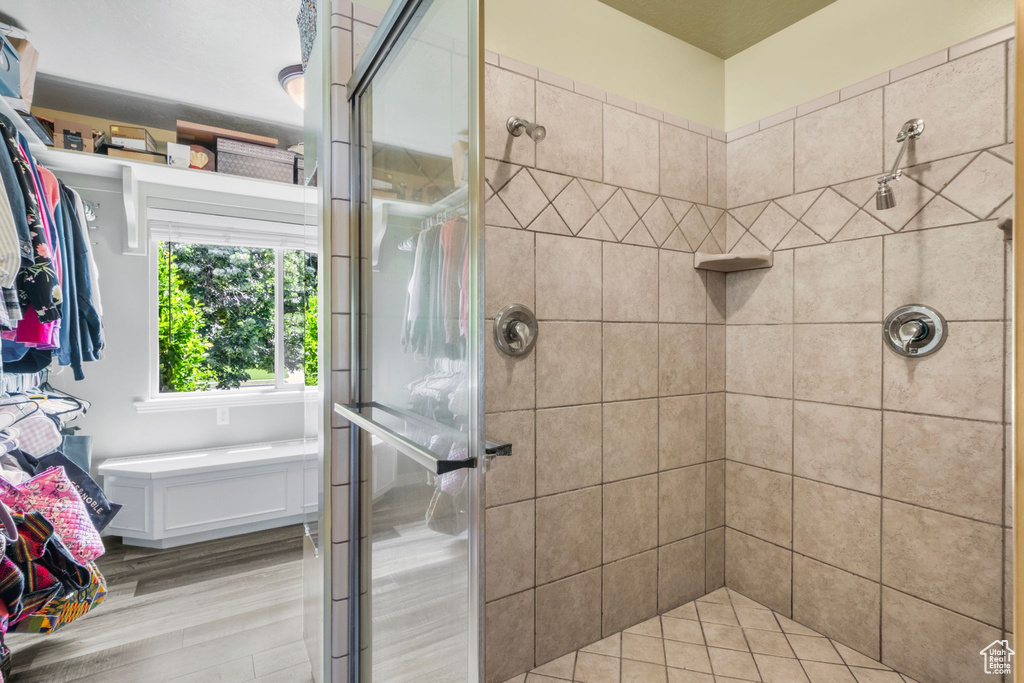 Full bath featuring a stall shower and wood finished floors