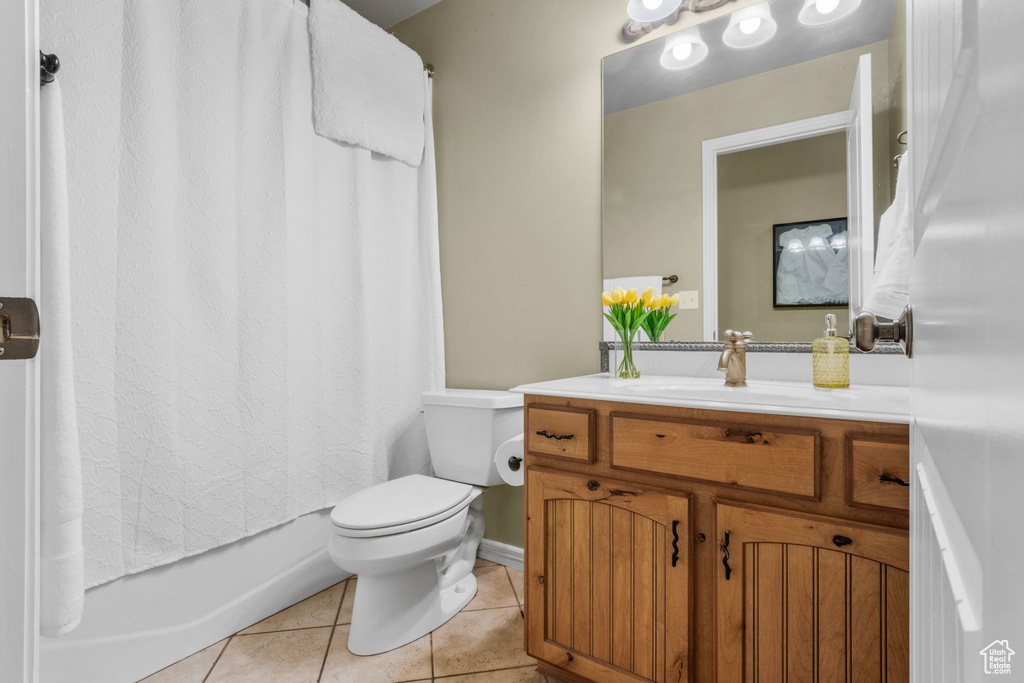 Full bath with vanity, tile patterned floors, and shower / bath combo with shower curtain