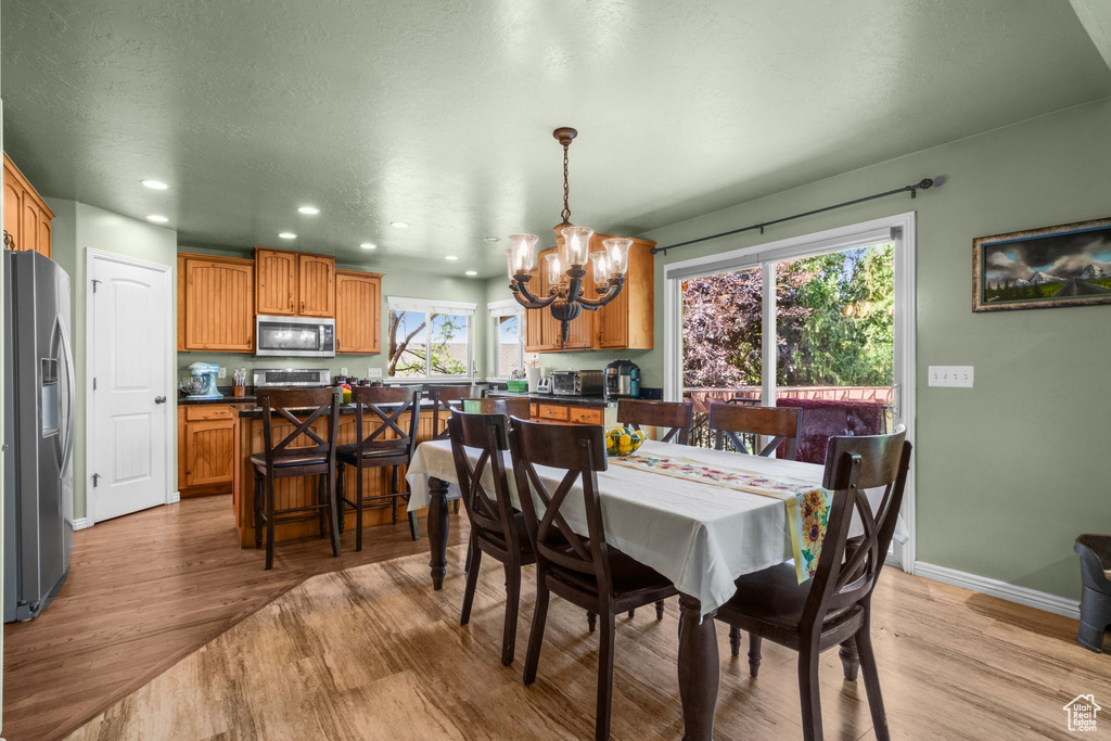 Dining space with a chandelier, light wood-type flooring, and recessed lighting