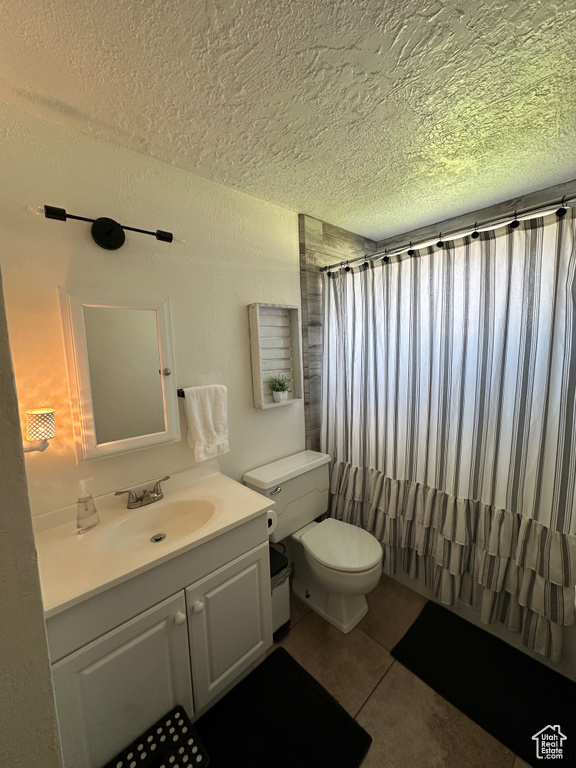 Full bath with a textured ceiling, vanity, tile patterned flooring, and a shower with curtain
