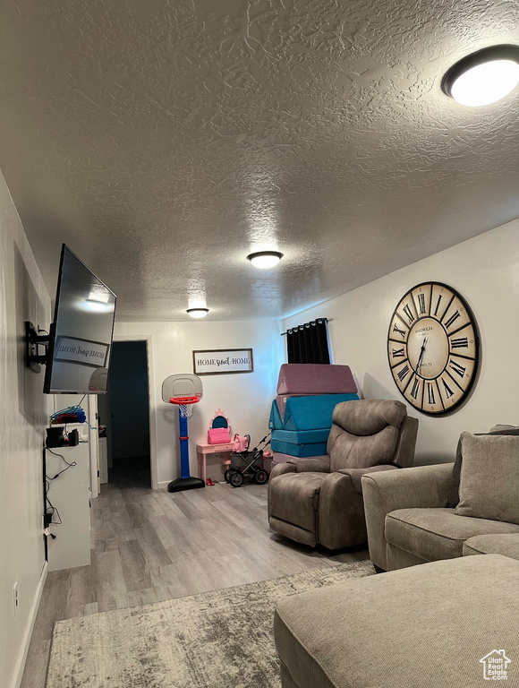 Living area featuring wood finished floors and a textured ceiling