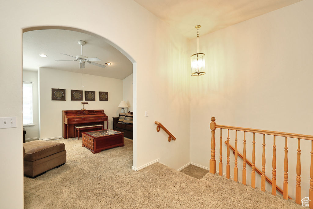 Stairway featuring carpet, a ceiling fan, arched walkways, and recessed lighting