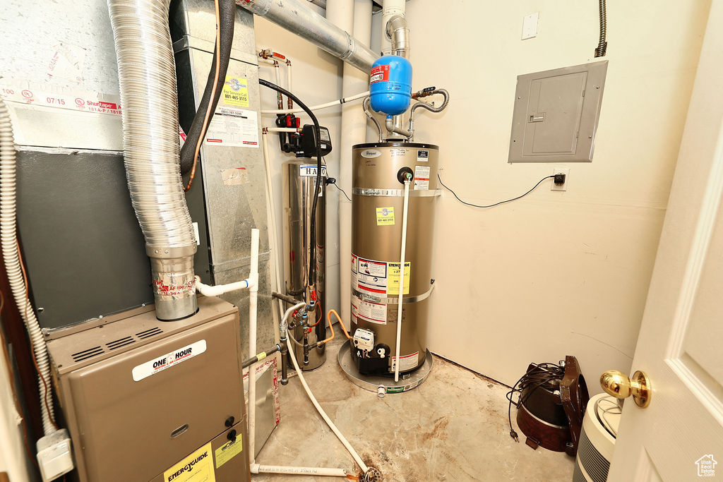 Utility room featuring electric panel, water heater, and heating unit