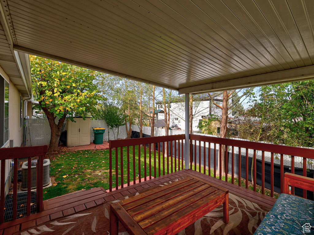 Wooden terrace with a fenced backyard